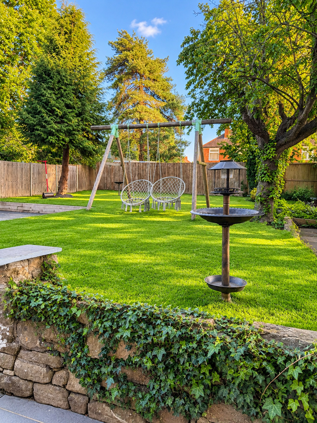 Garden with swing and planted borders at Ivie Lodge