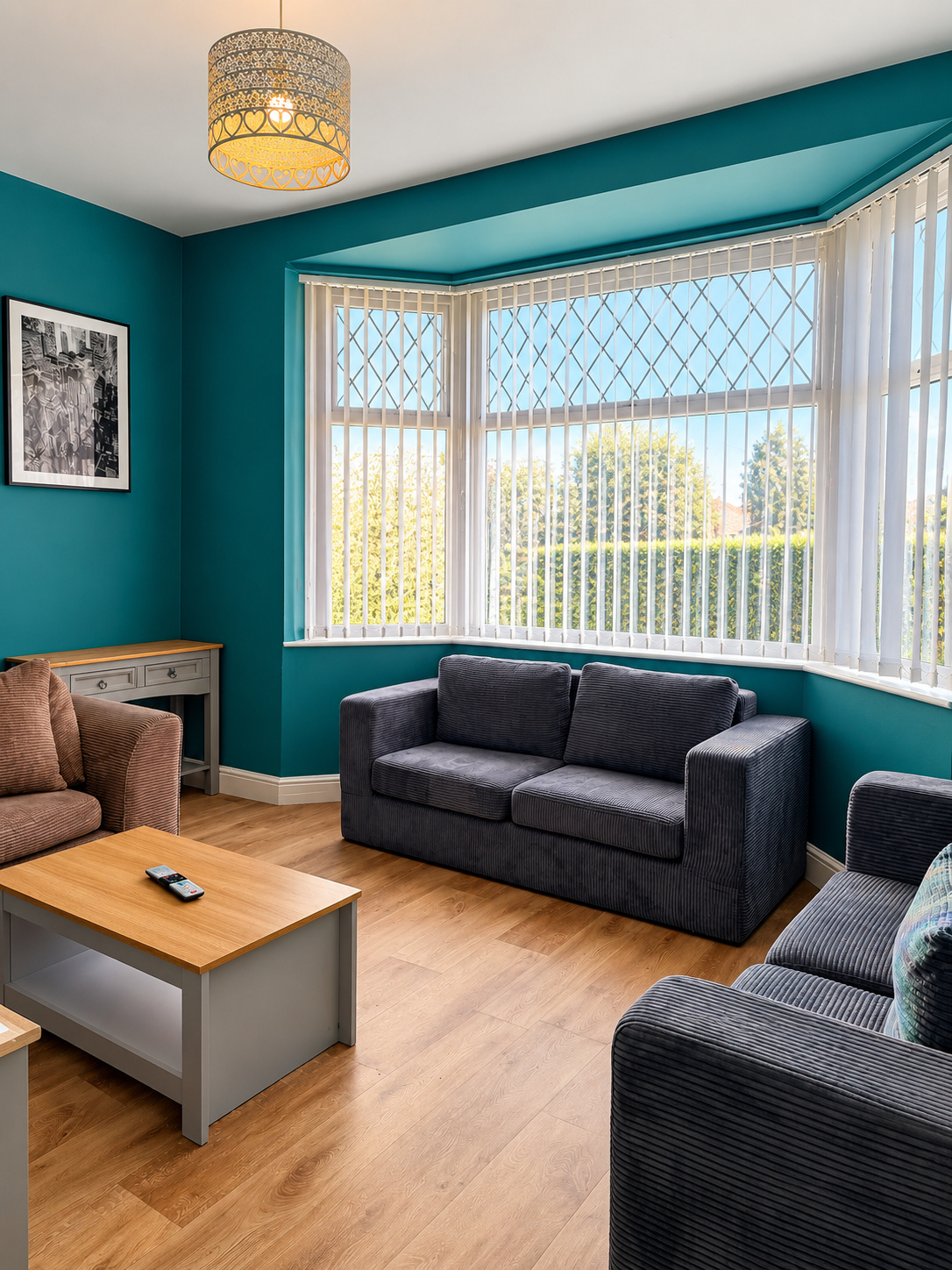 Bright lounge with teal feature wall and bay window at Ivie Lodge