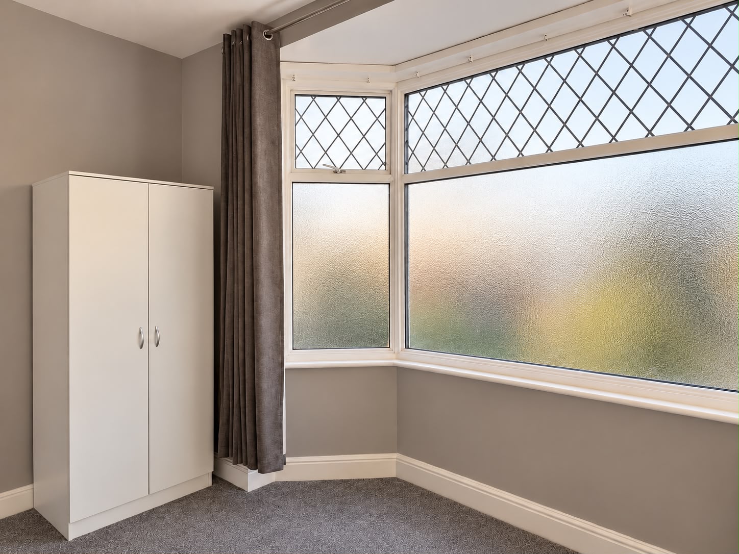 Bedroom with bay window and wardrobe at Ivie Lodge